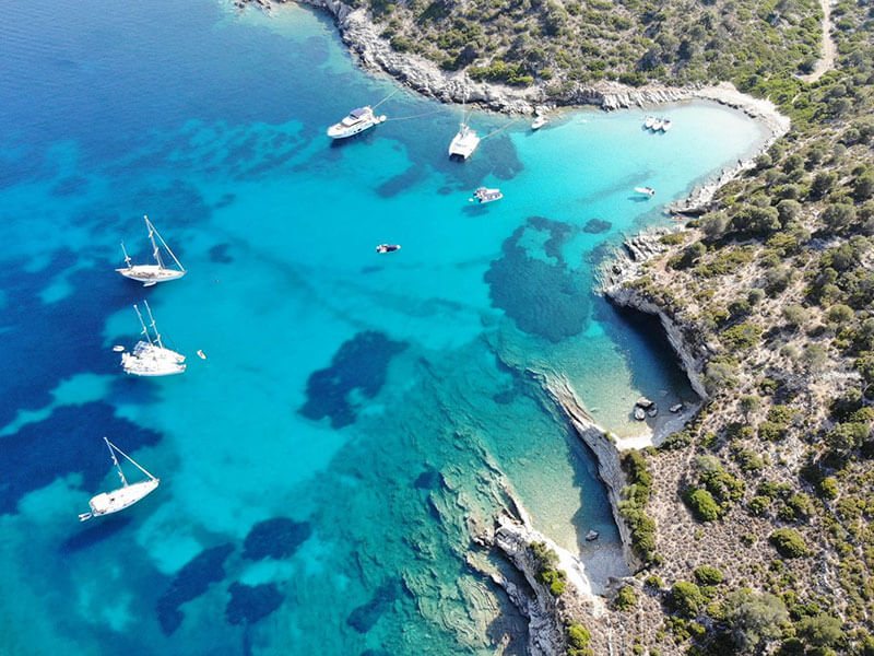 Kalamos, yachts anchored over turquoise water in a sheltered bay